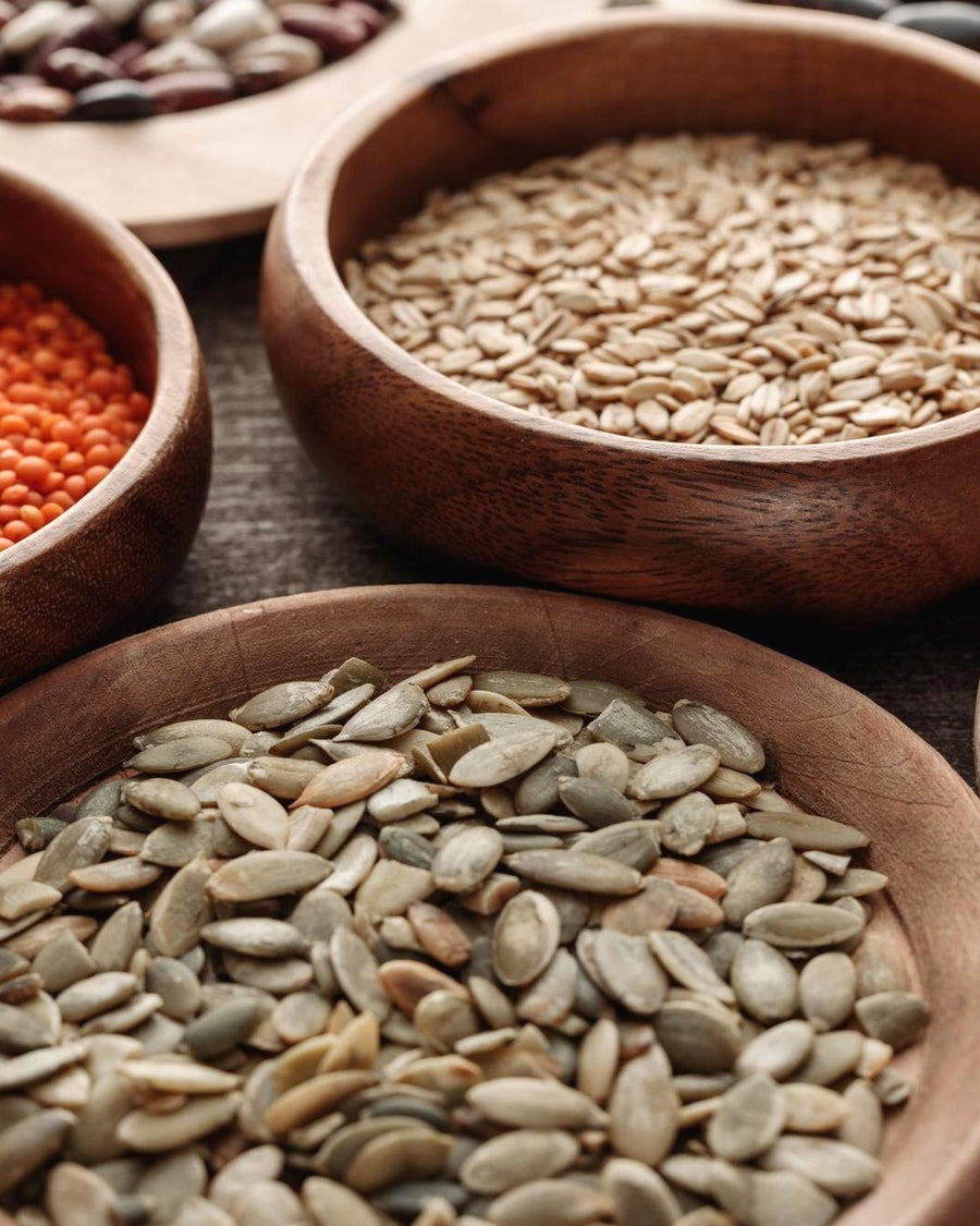 Whole grains and seeds in wooden bowls